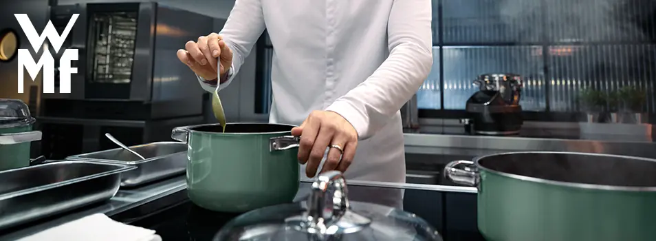 Chef cocinando con una batería de cocina WMF en color verde en una cocina profesional