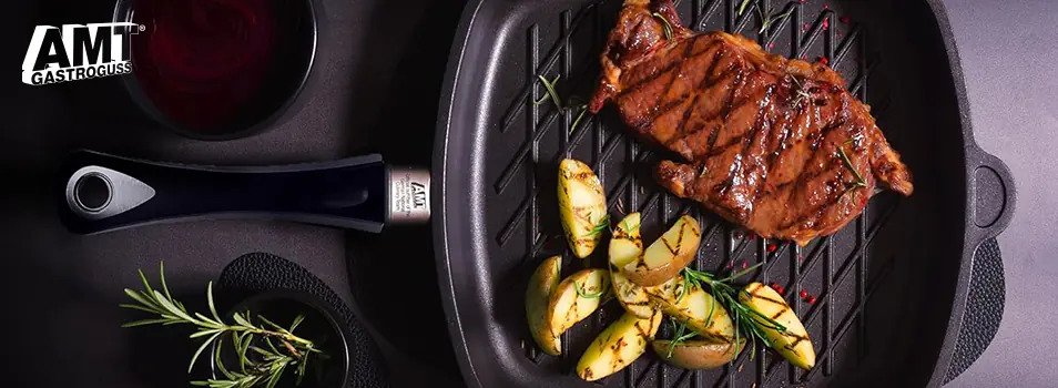 Sartén parrilla AMT Gastroguss con un corte de carne asada, papas y romero