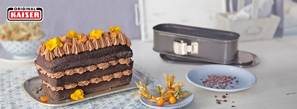 Pastel de chocolate en capas junto a un molde desmontable rectangular KAISER