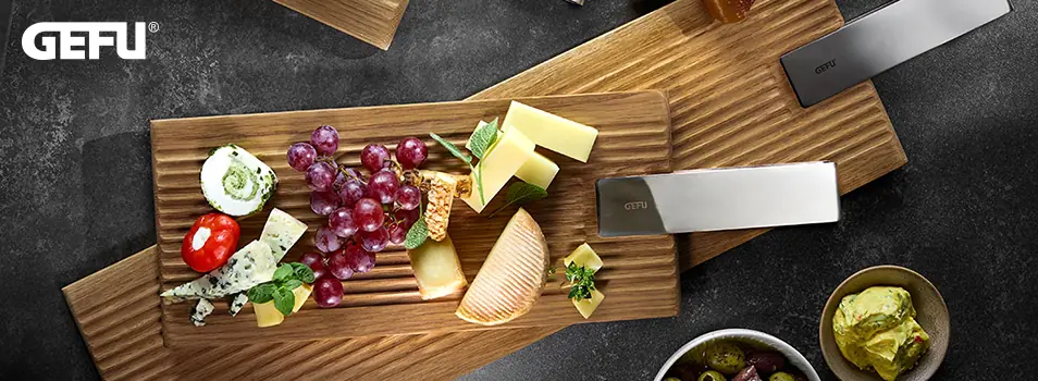 Tablas de madera GEFU con quesos, uvas y cuchillos de acero inoxidable